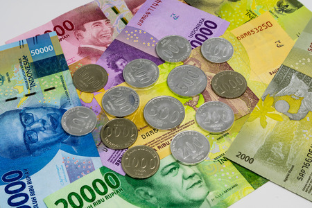 Closeup shot of Indonesia Rupiah banknotes and coins in white background.