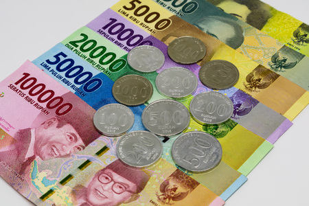 Closeup shot of Indonesia Rupiah banknotes and coins in white background.の写真素材