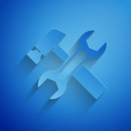 Paper cut Crossed hammer and wrench spanner icon isolated on blue background. Hardware tools. Paper art style. Vectorのイラスト素材