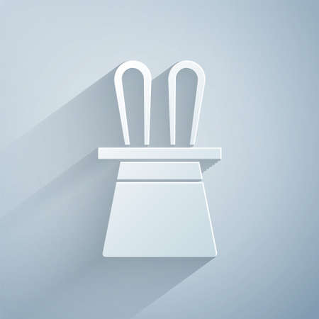 Paper cut Magician hat and rabbit ears icon isolated on grey background. Magic trick. Mystery entertainment concept. Paper art style. Vectorのイラスト素材