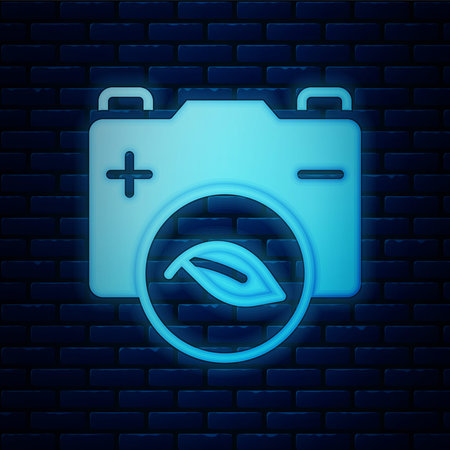 Glowing neon Eco nature leaf and battery icon isolated on brick wall background. Energy based on ecology saving concept. Vectorのイラスト素材