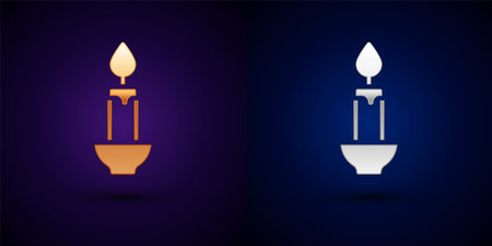 Gold and silver Burning candle icon isolated on black background. Cylindrical candle stick with burning flame. Vectorのイラスト素材