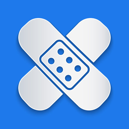 Paper cut Crossed bandage plaster icon isolated on blue background. Medical plaster, adhesive bandage, flexible fabric bandage. Paper art style. Vector Illustrationのイラスト素材