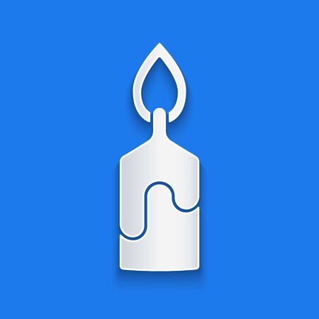 Paper cut Burning candle icon isolated on blue background. Cylindrical candle stick with burning flame. Paper art style. Vector Illustrationのイラスト素材
