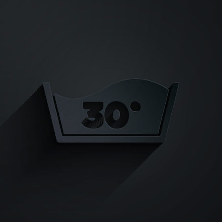 Paper cut Washing under 30 degrees celsius icon isolated on black background. Temperature wash. Paper art style. Vectorのイラスト素材
