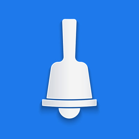 Paper cut Merry Christmas ringing bell icon isolated on blue background. Alarm symbol, service bell, handbell sign, notification. Paper art style. Vectorのイラスト素材