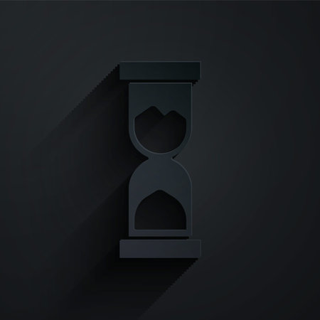 Paper cut Old hourglass with flowing sand icon isolated on black background. Sand clock sign....