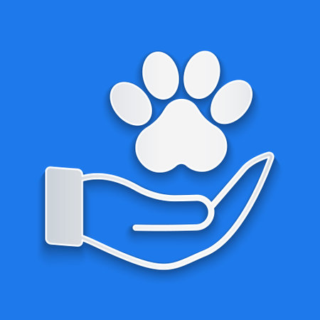 Paper cut Hands with animals footprint icon isolated on blue background. Pet paw in heart. Love to the animals. Paper art style. Vectorのイラスト素材