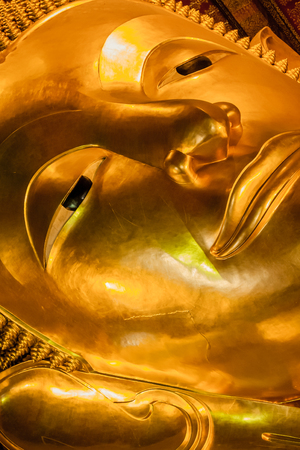 The face of big Reclined Buddha statue lay down in the Wat Pho temple, Bangkok, Thailand.の写真素材