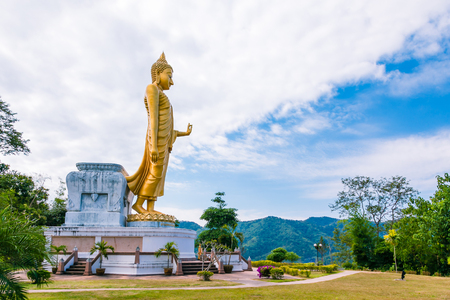 Large golden Buddha statue standing on top of mountain.の写真素材