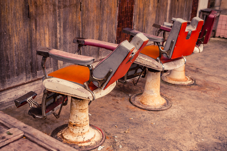 Group of old barber chairs on wooden background.の写真素材