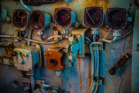 Broken and very old circular gauge and controller with lever handle inside the cockpit of abandoned...
