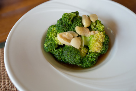 Stir fried broccoli with garlic in oyster sauce inside beautiful white round plate.の写真素材