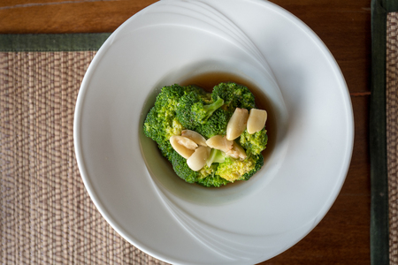 Stir fried broccoli with garlic in oyster sauce inside beautiful white round plate.の写真素材