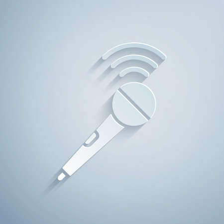 Paper cut Wireless microphone icon isolated on grey background. On air radio mic microphone. Speaker sign. Paper art style. Vectorのイラスト素材