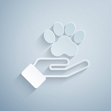 Paper cut Hands with animals footprint icon isolated on grey background. Pet paw in heart. Love to the animals. Paper art style. Vectorのイラスト素材
