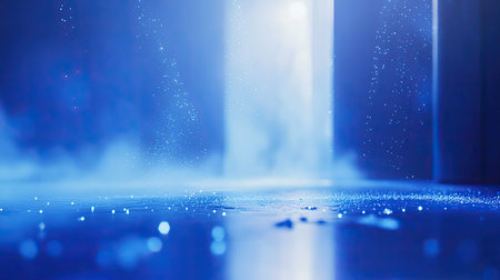 Abstract blue glowing particles falling on reflective surfaceの写真素材