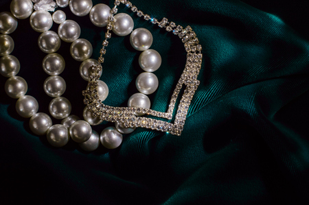 White pearl bracelet and necklace brilliant on dark green velvet.の写真素材