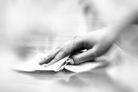 hand with wet wipe cleaning tableの写真素材