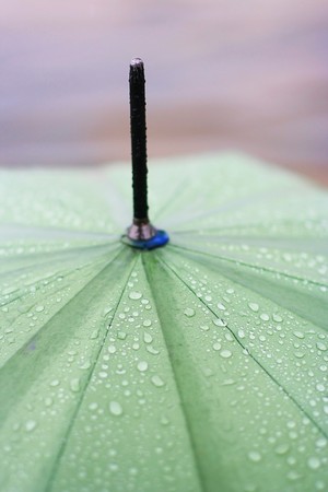 green umbrella with rain dropsの写真素材