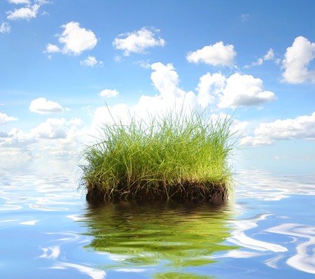 bright blue sky above water and green islandの写真素材