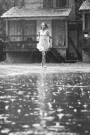 young woman running in the rain without umbrellaの写真素材