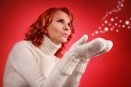 pretty young woman with snow flakes on red backgroundの写真素材