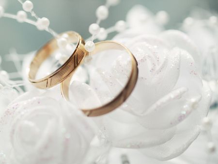 Closeup of wedding rings on a white decorationの写真素材
