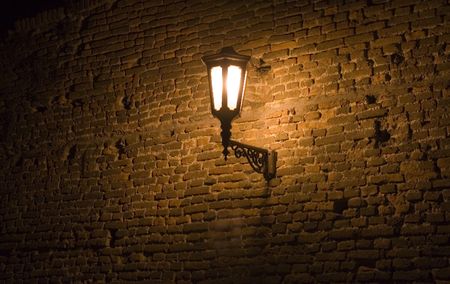 Retro street lamp on wall of old fortress/の写真素材