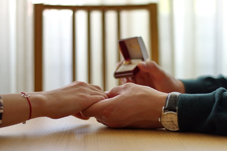 Closeup of man holding engagement ring and woman's handの写真素材