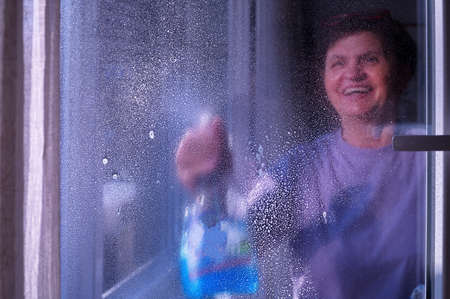 Portrait of senior woman  cleaning windows