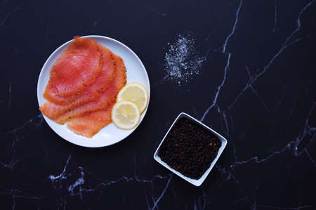Directly above shot of smoked salmon with spices on black backgroundの写真素材