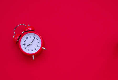 Red vintage alarm clock against red backgroundの写真素材