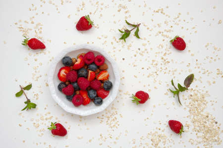 Flat lay of strawberries in white bowl against white backgroundの写真素材
