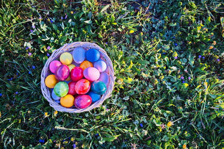 Directly above shot of Easter eggs in wicker basket on green meadowの写真素材