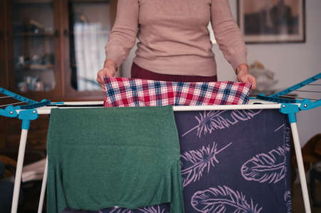 Midsection of woman hanging laundry on drying rack
