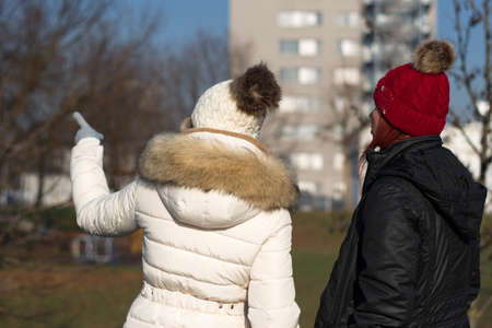 Rear winter portrait of two young women with knitted hatの写真素材
