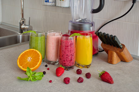 Colorful smoothies in glass with fresh fruits on kitchen deskの写真素材