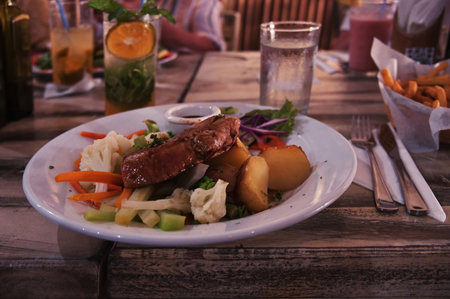 Tuna steak with potatoes and vegetables on rustic table