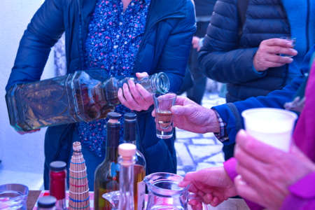 Midsection of woman pouring brandy from big bottleの写真素材