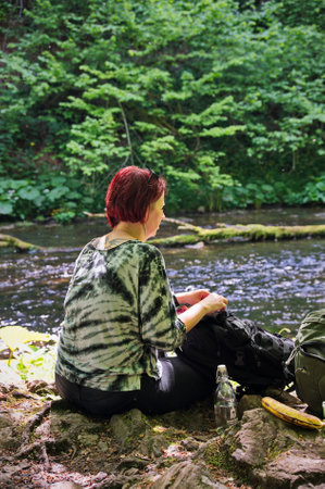 Portrait of red hair mature woman sitting in forestの写真素材