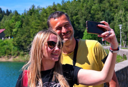 Mature couple using mobile phone and chatting with friends