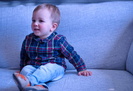 Portrait of cute little boy sitting on a sofa