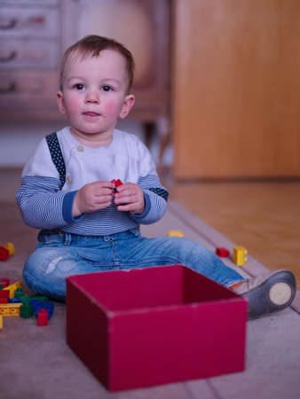 Portrait of cute little boy playing on the floorの写真素材