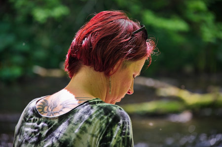 Portrait of red hair mature woman sitting in forestの写真素材