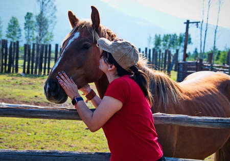 Mature woman with horse on the ranchの写真素材