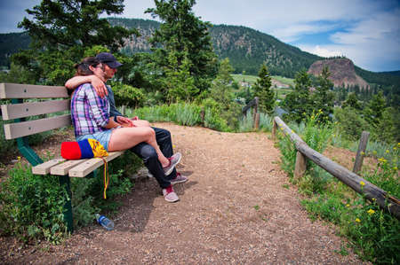 Mature couple sitting on the bench over the lakeの写真素材