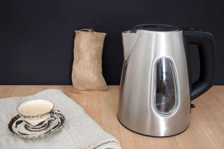 Metal container and coffee cup on the wooden table