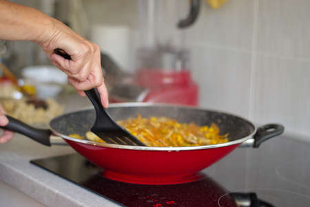 Midsection of woman cooking on the stoveの写真素材