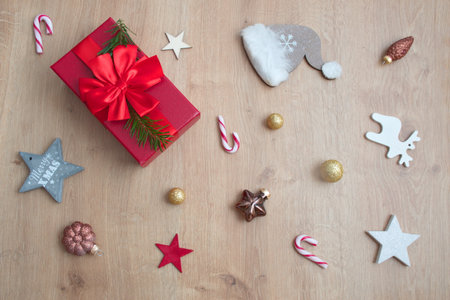 Flat lay of red Christmas gift and Christmas ornaments against the wooden backgroundの写真素材